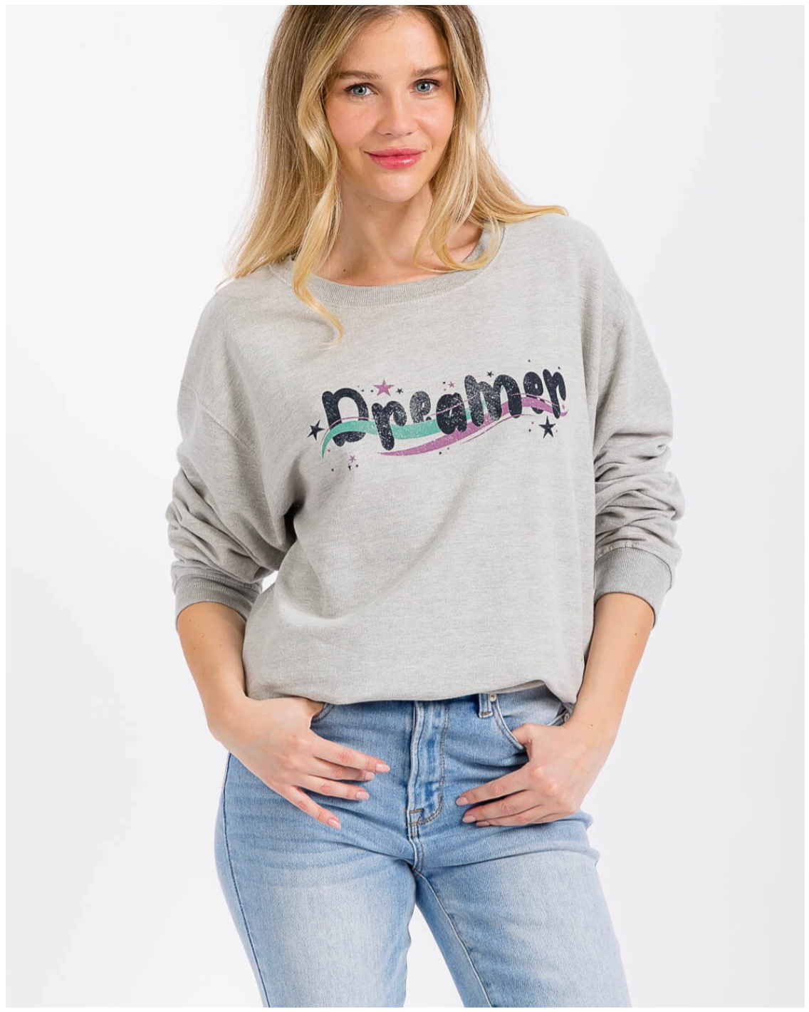 Woman wearing a gray sweatshirt with 'Dreamer' text on a white background
